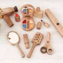 A wooden beauty salon set laid out on a white surface, including items such as a hairbrush, mirror, hair dryer, hair straightener, scissors, nail polish, lipstick, perfume bottle, eye shadow palette with brush, and cream.