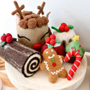 Felt Christmas decorations including a reindeer, gingerbread man, log, and candy cane on a white surface.