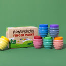 Set of colorful finger paint jars with a box labeled 'Honeysticks Finger Paint' on a green background.