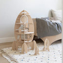 Wooden rocket-shaped shelf in a child's room with a bed and rug.