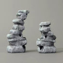 Two stone sculptures on a gray background
