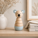Wooden toy stacker with animal design on a shelf with decorative items.