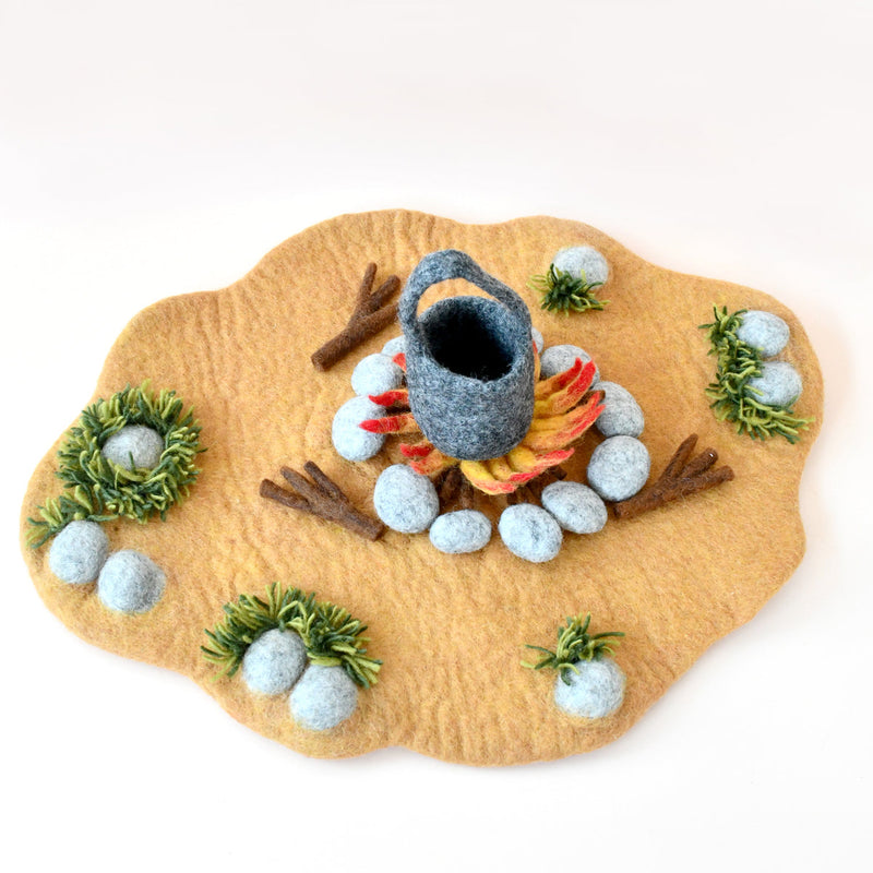 Felt play mat with a campfire scene including a kettle, logs, and grass.