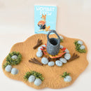 Felt play mat with campfire scene, felt pot, and 'Wombat Stew' book on a beige background