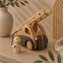 Wooden toy car with a figure on a beige surface with a vase and plant in the background
