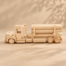 Side view of the Bartu Dallas natural wooden logging truck and trailer loaded with wooden logs on a warm beige textured background.