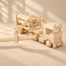 Bartu Montana wooden truck demonstrating its extended crane holding a log, with five logs on the trailer.