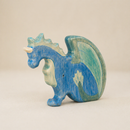 Blue and green dragon figurine on a beige background