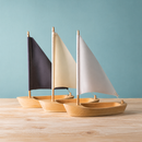 Colour comparison showing Bumbu Toys sailing boats with dark, cream and white sails.