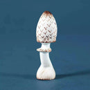 A small decorative mushroom figurine with a white body and brown distressed detailing, standing on a blue background.