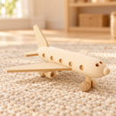 Bartu Sully natural wooden toy passenger plane at a front three-quarter angle on a warm woven rug.