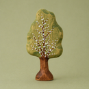 Wooden tree figurine with a green trunk and brown leaves on a green background