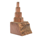 A wooden pop-up castle toy made from a single piece of wood, with a natural brown finish and multiple layers forming the castle structure.